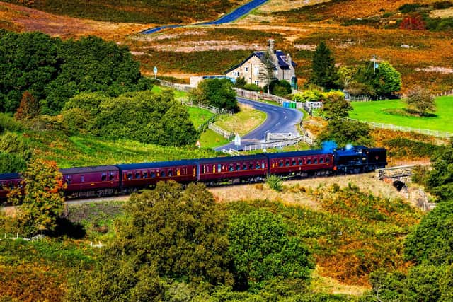 A steam locomotive powers along the North Yorkshire Moors Railway from Pickering towards Whitby.