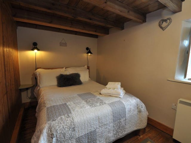 A beamed double bedroom within the cottage.