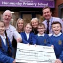 Hunmanby Primary School receives a cheque from the Horseshoe Inn Dave Well and Holly Shaw from the pub with School Governor Jill Tiffany and Head Conrad Fox with pupils.