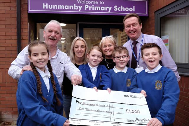 Hunmanby Primary School receives a cheque from the Horseshoe Inn Dave Well and Holly Shaw from the pub with School Governor Jill Tiffany and Head Conrad Fox with pupils.