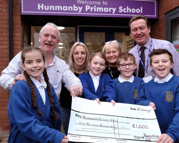Hunmanby Primary School receives a cheque from the Horseshoe Inn Dave Well and Holly Shaw from the pub with School Governor Jill Tiffany and Head Conrad Fox with pupils.