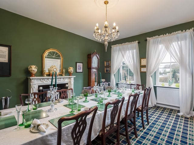 An elegant dining room with feature fireplace has plenty of space and natural light.