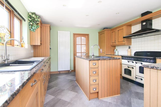 The kitchen is both modern and bright, and boasts fitted oak hand-built units and granite work surfaces, along with sliding doors to access the balcony.
