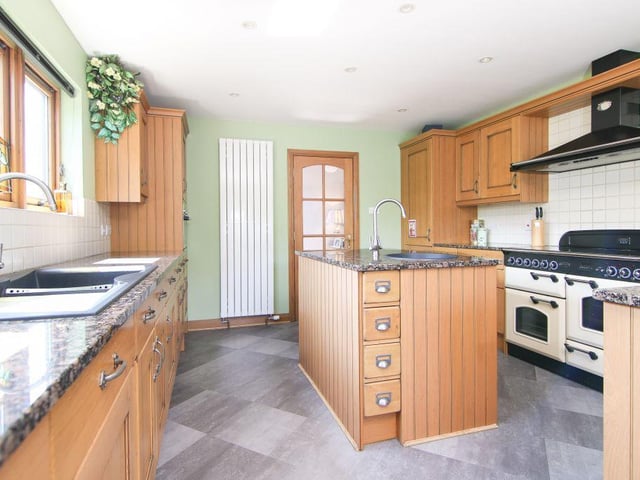 The kitchen is both modern and bright, and boasts fitted oak hand-built units and granite work surfaces, along with sliding doors to access the balcony.