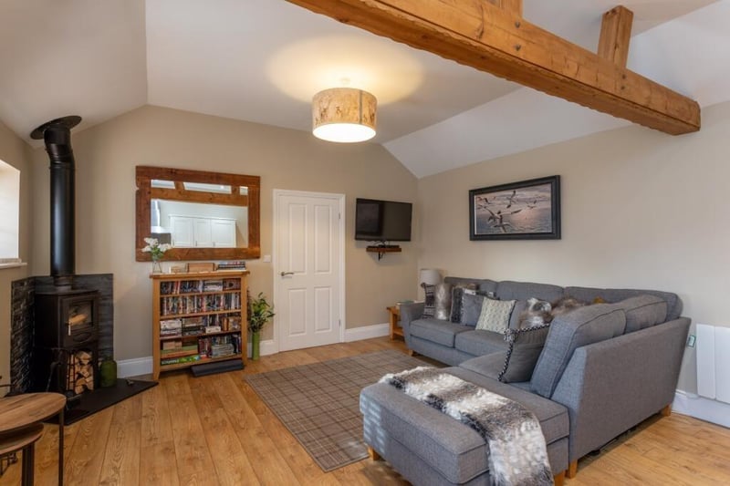 A cosy yet open plan sitting room with feature log burner in one of the holiday cottages.