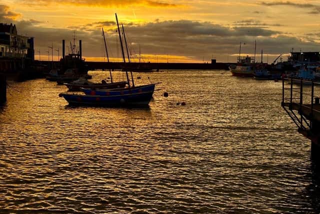An orange sunrise above the harbour, by Ian Sandy.
