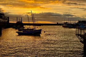 An orange sunrise above the harbour, by Ian Sandy.