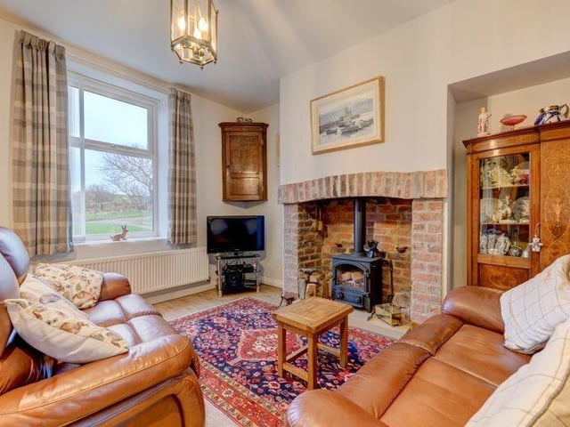 A cosy lounge with rustic brick fireplace and stove has stunning views.