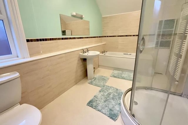 A spacious bathroom is equipped with both bath and separate shower cubicle.