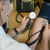 File photo of a GP checking a patient's blood pressure.