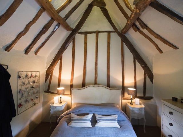 A quaint beamed bedroom within the cottage.