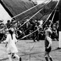 Children Maypole dancing.