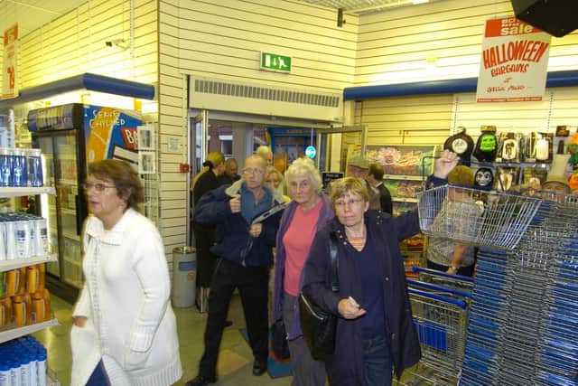 The first shoppers through the doors in September 2005 grab a basket and prepare to find a bargain.