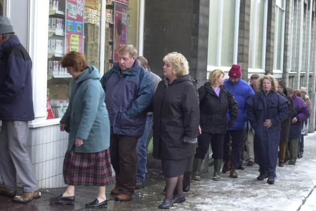 Shoppers queue in the snow and ice for the doors to open at 9am in January 2005.