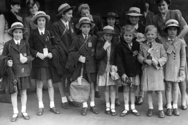 A group of girls from Putney High School waiting at London's King's Cross Station for a train to Bridlington in Yorkshire, where they were to spend a seven week seaside holiday.