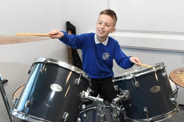 Charlie, 11, trying out the drum kit in the new music and drama room.