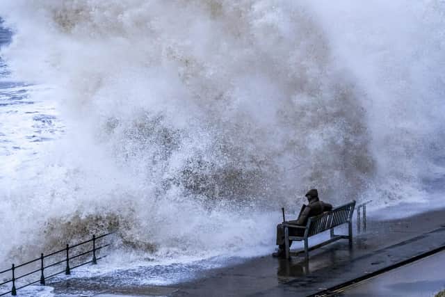 The iconic statue of "Freddie Gilroy" takes a pounding from huge waves. Picture by Tony Bartholomew.