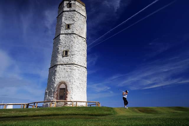 A golfer tees off by the old chalk tower lighthouse. There are plans underway to reopen this building to the public.