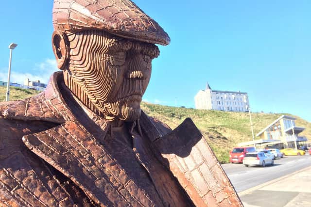 The 'Freddie Gilroy and the Belsen Stragglers' statue is a popular stop-off point. In the background stands the impressive Clifton Hotel.