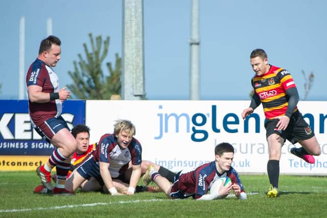 Jonty Holloway crashes over the try line