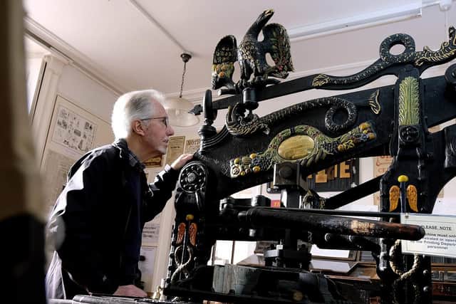 Volunteer Mike Pitt views the Columbia printing press