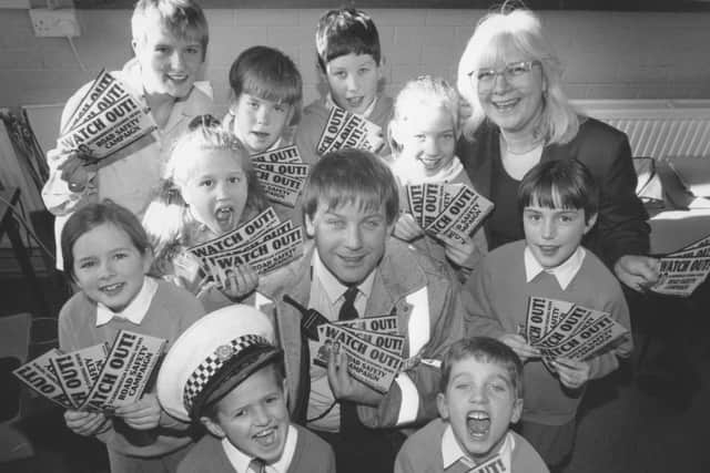 Launching the SEN road safety stickers at Gladstone Road Junior School are TC Frank Godber, with SEN reporter Catherine Cunningham, back left, and Clare Dobson, back right, from SEN newspaper sales, with some of the pupils from the school, back in February 1997.