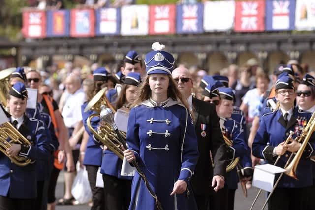 A band being led along the seafront.