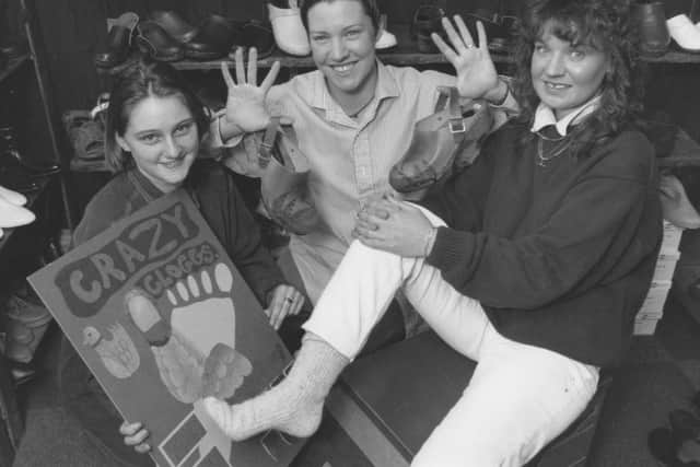 In March 1996, Fashion and Costume Design student Joanne Phillips from Yorkshire Coast College, left, offers her design of a fashion clog to the judge Cath Mann of Bjorn Clogs, right, as trainee lecturer Jemma Whitby Boot looks on.