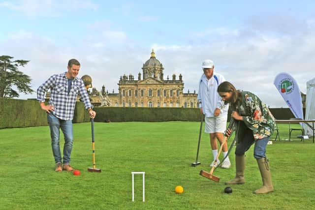 Presenters Matt Baker and Anita Rani play croquet on the lawns infront of the stately home under the watch of Derek Knight from the Croquet Association.