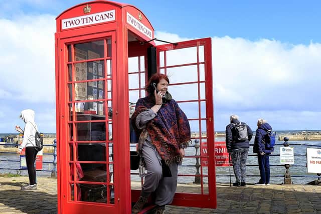 Suzie Devey makes a call at her art installation on the seafront.
194425j