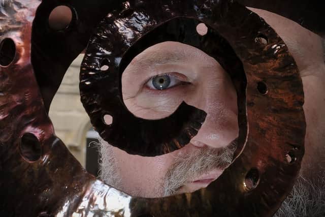 Sculptor Derek Anderson with a piece of his work.
194425c