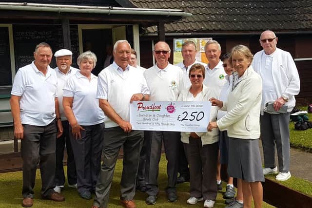 Members at Burniston and Cloughton Bowls Club are presented with a cheque from Proudfoot.