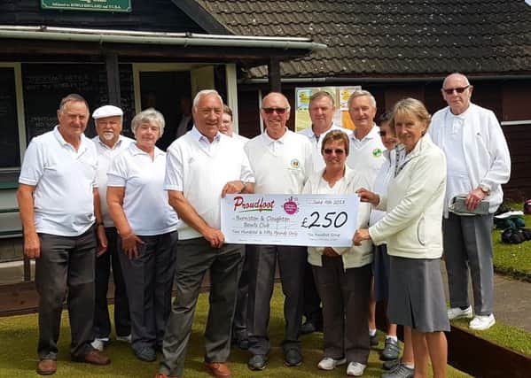 Members at Burniston and Cloughton Bowls Club are presented with a cheque from Proudfoot.