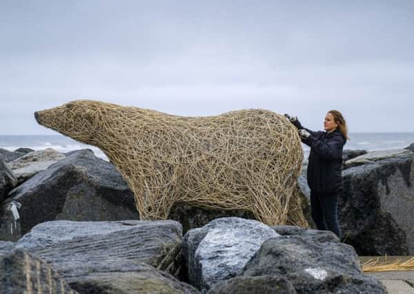Whitby sculptor Emma Stothard at work installing her life-size Polar bear  made from willow on the pier at Staithes
 Â©Tony Bartholomew