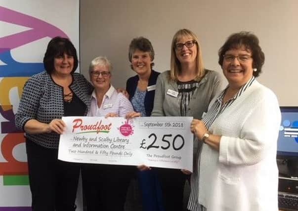 Proudfoot director Valerie Aston presents the cheque to library trustees Lesley Newton, June Watson, Tricia Whelan and Judy Woodroffe.