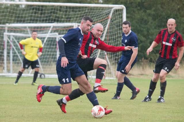 West Pier Reserves (red and black) battle for the ball at Cayton Athletic. Picture by Steve Lilly.