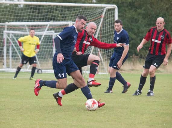 West Pier Reserves (red and black) battle for the ball at Cayton Athletic. Picture by Steve Lilly.