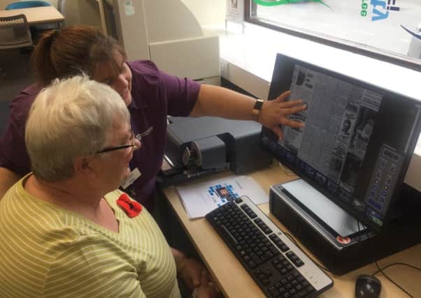 Debby Foulkes demonstrates one of the new scanners to a customer.