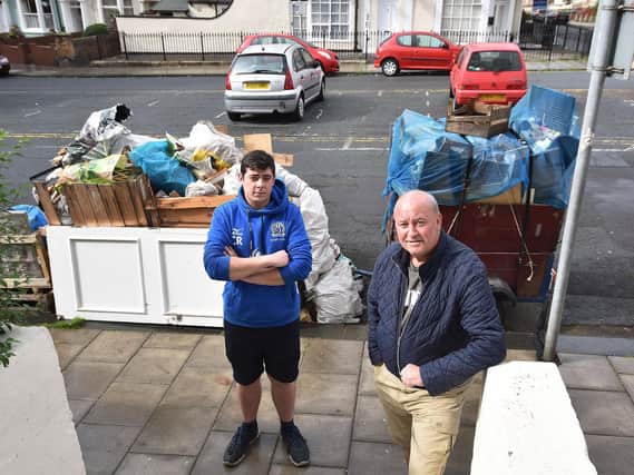 Charlie Reid (left) and Martin Whelan standing in front of two piles of rubbish that are now almost fully removed.