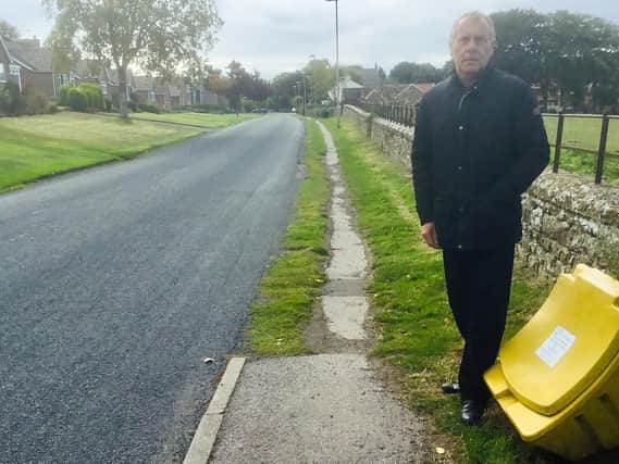 Cllr Derek Bastiman stands at the start of the stretch of footway that is to be upgraded.