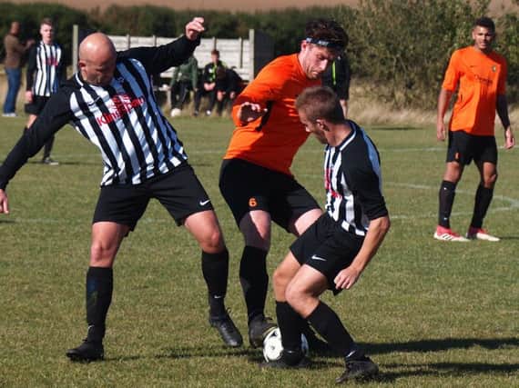 Edgehill skipper Joe Gallagher grapples with two Sherburn opponents. Picture by Steve Lilly.