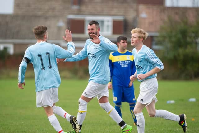 Travis Wood is congratulated after scoring Cask's first goal in their 4-0 win over Fylingdales. Picture by Andy Standing.