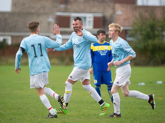 Travis Wood is congratulated after scoring Cask's first goal in their 4-0 win over Fylingdales. Picture by Andy Standing.