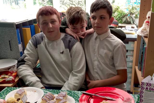 Liam Studholm, Owen Shevels and Jamie Maclaren man the cake stall.