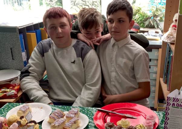 Liam Studholm, Owen Shevels and Jamie Maclaren man the cake stall.
