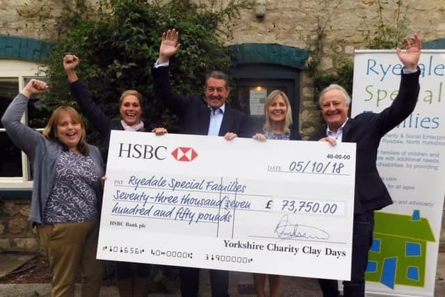 Chris Blundell (centre) presents a cheque to Ryedale Special Families.