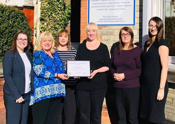 Victoria Moss and Hayley Garnett are presented with a gold certificate from Helen Soutar (legacy partnership manager for Cancer Research UK) as colleaugues Natalie Brooke, Debra Hibbert and Christina Severn.