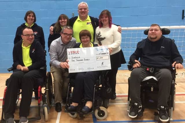 The Scarboccia group is presented with a cheque for £1,000 by Tesco store manager Paul Best.