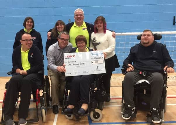 The Scarboccia group is presented with a cheque for Â£1,000 by Tesco store manager Paul Best.