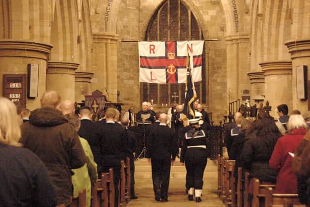 The standard bearers walking down the aisle at the beginning of the service.